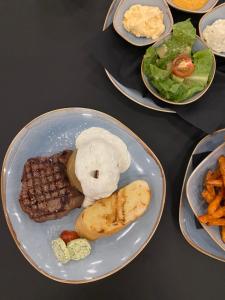 汉堡OLÉ Hotel的盘子上的食物,包括肉、蔬菜和薯条