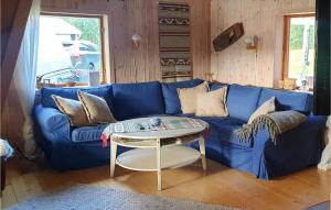 斯特伦松德Cozy Home In Strmsund With Lake View的客厅配有一张蓝色的沙发,配有一张桌子