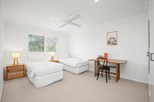 拜伦湾Lawson Beachfront的白色的客厅配有桌子和沙发