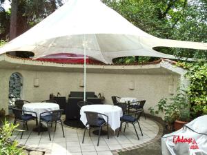 瓦尔多夫劳伯格酒店的一个带桌椅和遮阳伞的庭院