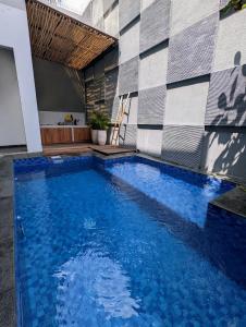 万隆Cottonwood 4BR Villa Sutami with Pool Netflix BBQ的一座大型蓝色游泳池,位于大楼旁边