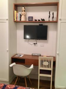 里约热内卢Studio Rio Beira Mar的客房设有书桌、电视和椅子