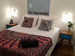 里约热内卢Studio Rio Beira Mar的一间卧室配有一张带枕头的大床和两张桌子