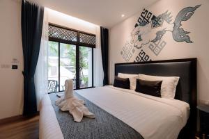 奥南海滩Sabai Hotel Aonang的一间卧室配有一张大床,上面有一双鞋