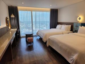 仁川市JN PARK Hotel的酒店客房设有两张床和一张桌子。