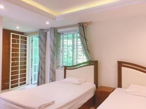 下龙湾RosePark Tuan Chau的带窗户的客房内的两张床