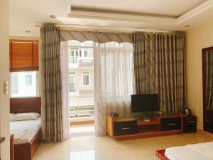 下龙湾RosePark Tuan Chau的一间卧室配有一张床、一台电视和一个窗口