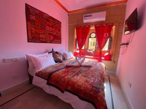 斋沙默尔Hotel Murad Haveli Jaisalmer的一间卧室配有床和红色窗帘的窗户