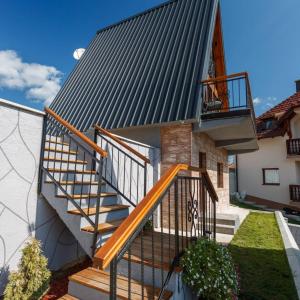 新瓦罗什Zlatarski čardaci的一座带金属屋顶的房屋,设有楼梯