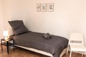 伊瑟隆Spacious 3 Room Apartment with Wifi and Balcony的一间卧室配有一张床和一张白色椅子