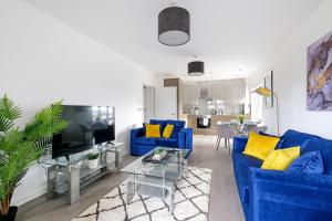 SurbitonTown Center 2 bed Serviced Apartment 08 with parking, Surbiton By 360Stays的客厅配有蓝色的沙发和黄色的枕头。