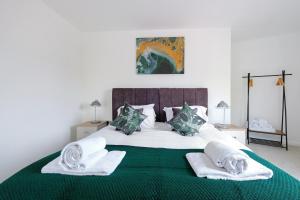 SurbitonTown Center 2 bed Serviced Apartment 08 with parking, Surbiton By 360Stays的一间卧室配有一张大床和毛巾