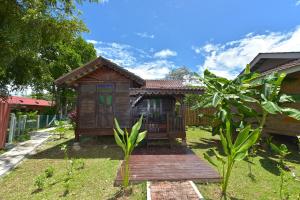 珍南海滩Collection O 90622 Sehijau Cenang的庭院中带木甲板的小房子