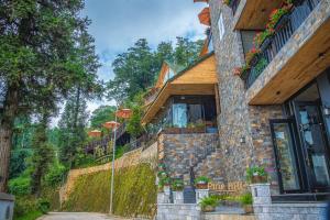 萨帕Sapa Pine Hill Eco Lodge的花朵边的建筑