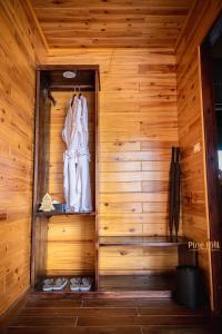 萨帕Sapa Pine Hill Eco Lodge的木墙上挂着白色长袍的桑拿