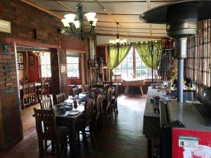 斯普林斯Eastwoods Lodge的餐厅内带桌椅的用餐室