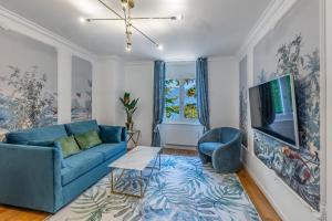 TerritetGarden of Eden 1-bedroom apartment – Lakefront的客厅配有蓝色的沙发和电视