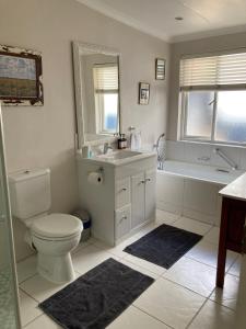 约翰内斯堡Home From Home, Waverley B&B, Johannesburg的浴室配有卫生间、浴缸和水槽。