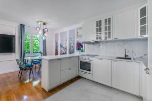 TerritetSoft Glam 1-bedroom appt - Lake & Mountain View的白色的厨房配有白色的橱柜和桌子