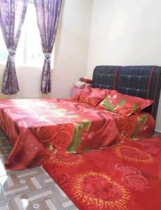 Kampong Alor GajahNor Su Homestay的一间卧室配有两张带红色毯子和玫瑰的床