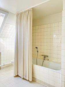 腓特烈港aday - Frederikshavn City Center - Charming double room的带浴缸和淋浴帘的浴室