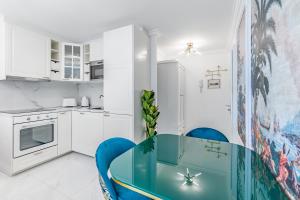 蒙特勒Tropical studio with a balcony - Lake View的厨房配有蓝色的桌子和蓝色的椅子