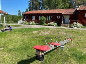 卢德维卡Skogshemmet的坐在院子里草地上的红色长凳