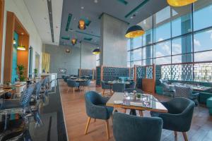 达曼Dana Rayhaan by Rotana的餐厅设有桌椅和窗户。