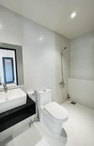 芹苴MIDMOST HOUSE的浴室配有白色卫生间和盥洗盆。