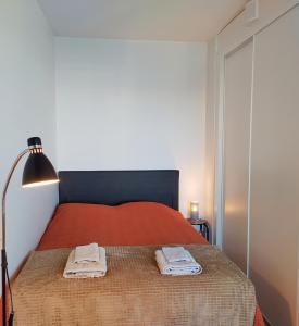 塞伊奈约基Ihana uusi huoneisto, hyvällä sijainnilla的一间卧室配有红色的床和2条毛巾