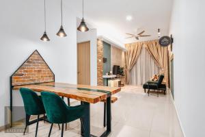 吉隆坡Legasi Kampung Baru Guesthouse的一间带木桌和绿色椅子的用餐室