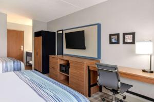 布兰森AmericInn by Wyndham Branson & Conference Center的酒店客房配有一张床和一张书桌及一台电视