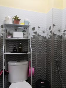 淡马鲁Darney's Homestay Kg Bangau Tanjung的浴室配有卫生间,墙上挂有鲜花
