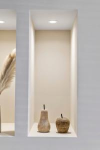 布莱克浦The Burlington by STAMP SA的两个花瓶坐在一个房间里的一个架子上