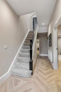 布莱克浦The Burlington by STAMP SA的房屋内的楼梯,拥有白色的墙壁和木地板