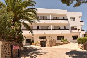 伊维萨镇Hostal Marblau Ibiza的前面有棕榈树的建筑