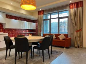 巴库Megafun Luxury Family Apartment的一间带桌椅和沙发的用餐室