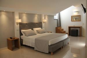 莱万托民族酒店的卧室配有一张带白色床单和枕头的大床。
