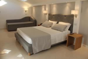莱万托民族酒店的一间卧室配有一张大床和一张沙发