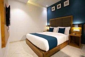 孟买HOTEL ASTROS的一间卧室设有一张蓝色墙壁的大床