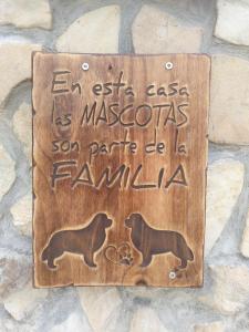 EntrambasaguasPosada Pet Friendly El Molino de Cantabria的石墙上带有两只狗的木标志
