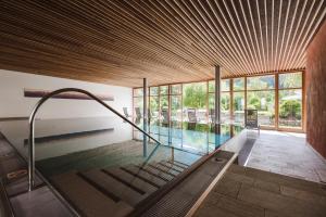 圣维吉利奥蒙蝶鞍酒店的一座带木制天花板的游泳池的房子