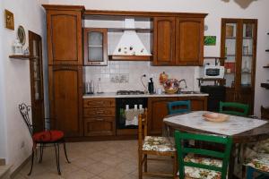 皮斯蒂奇La villa di campagna的厨房配有木制橱柜和桌椅