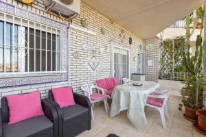阿尔姆尼卡Miramar 68的庭院配有粉红色的椅子和桌子