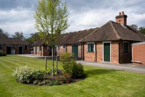 约克Stableside at York Racecourse的院子里有树的砖房