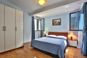 斯韦蒂·斯特凡Plava Vila Beach Apartments Sveti Stefan的一间卧室配有一张蓝色墙壁和木地板。