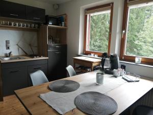 比尔的斯坦1 ZI Appartement Zauberwald的带木桌和椅子的厨房以及带窗户的厨房。