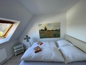 Borgholzhausen2 Zimmer Appartement的卧室配有一张白色床,墙上挂有绘画作品