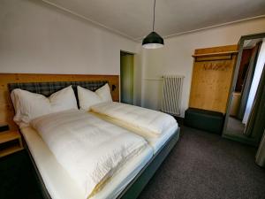 菲利苏尔Hotel Restaurant Rätia的一间卧室配有一张带白色床单的大床