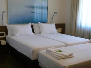 瓜尼佐Hotel Los Angeles的配有白色枕头的酒店客房内的两张床